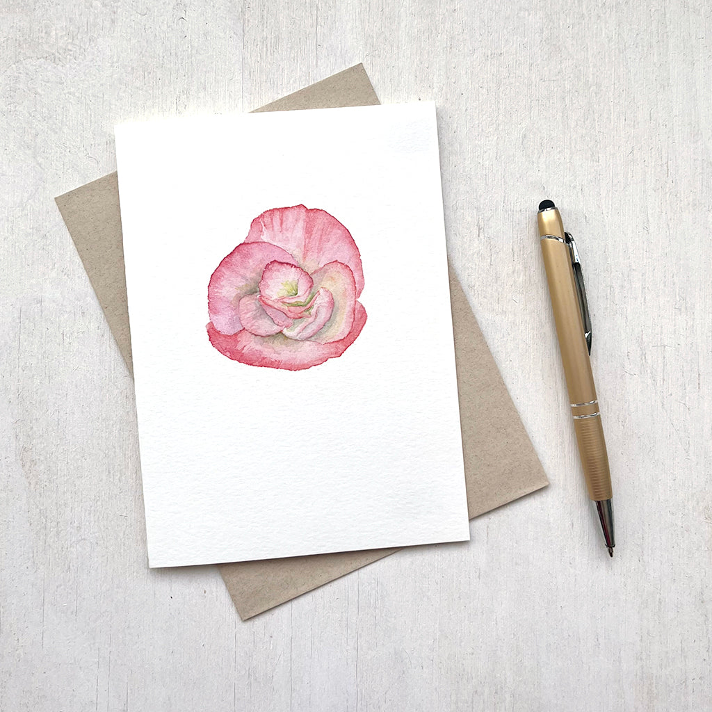 A lovely note card featuring a watercolour painting of a salmon-coloured begonia flower.