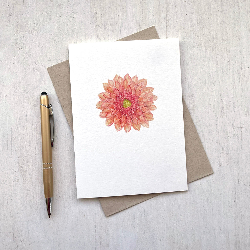 A note card with a lovely watercolor painting of a coral colored dahlia. Artist Kathleen Maunder.