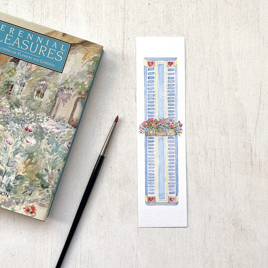 A paper bookmark featuring a delicate watercolour painting of a window box filled with colourful flowers.